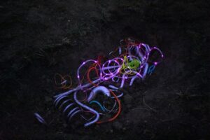 Neon-coloured clean wires in a dark background, possibly on the ground.